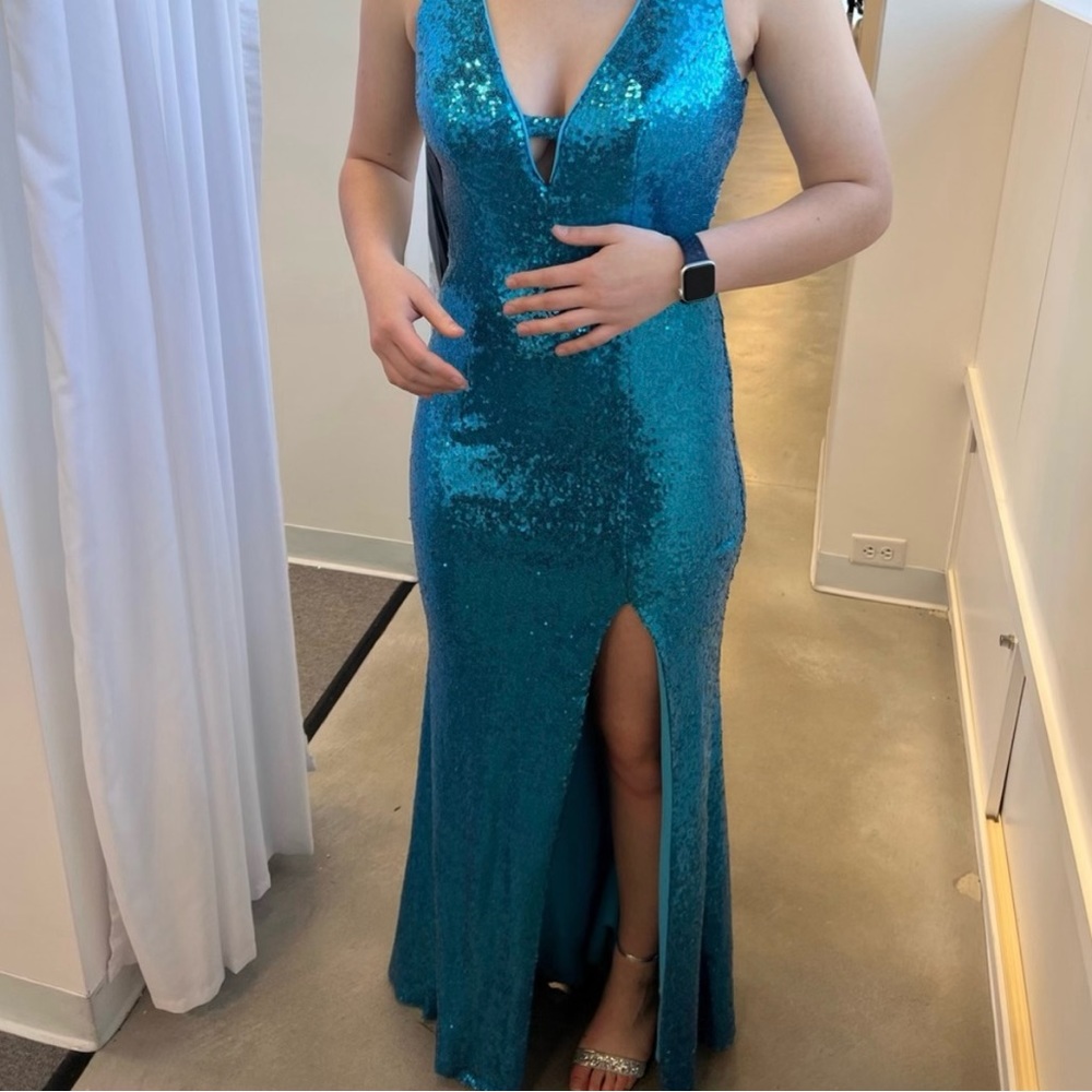 Teal sequin prom dress with an open back and a slit on the left leg